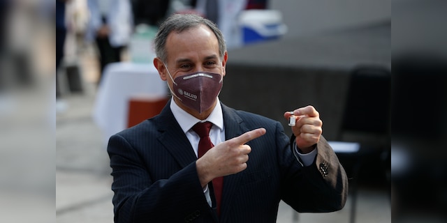 Mexico's Coronavirus Response Head, Hugo Lopez-Gatel, points to the vial of the COVID-19 vaccine while first being used by health workers at the General Hospital in Mexico City, early Thursday, December 24, 2020 (AP Photo / Eduardo Verdugo) )